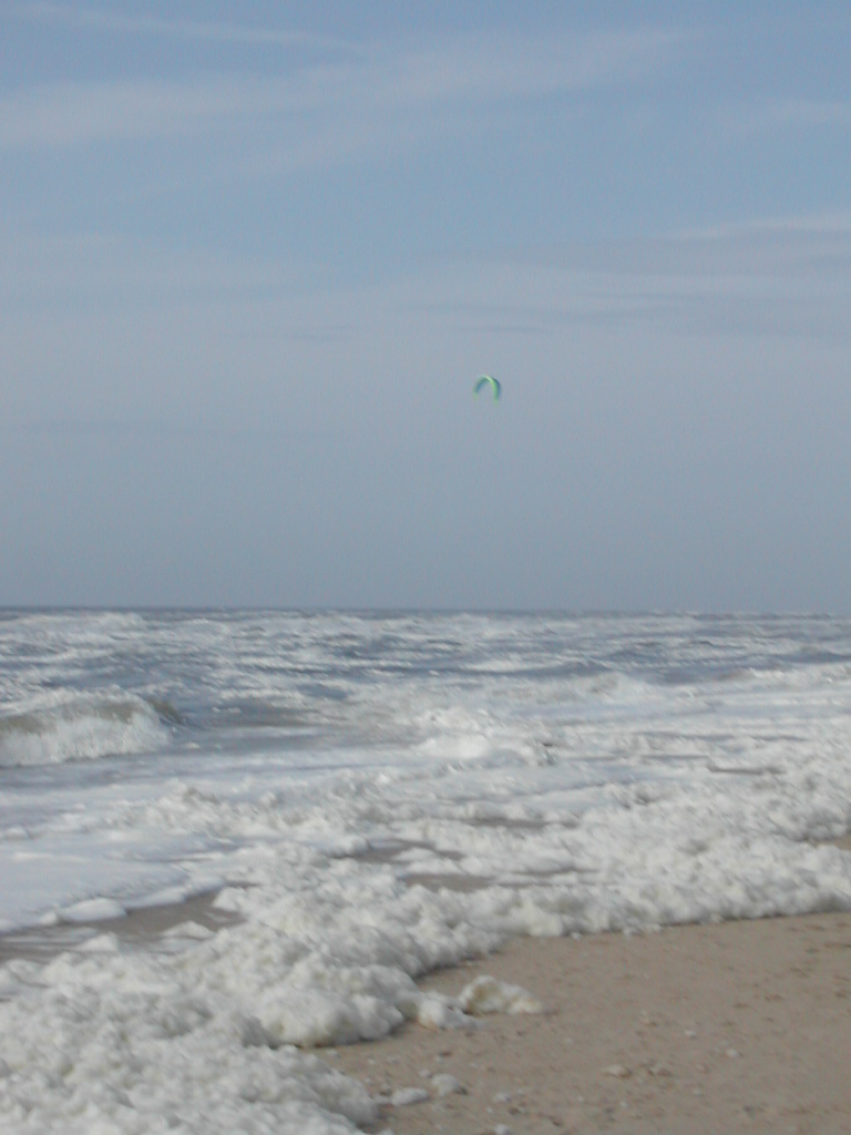 Een dude die aan een vlieger hing, en zo ging surfen. Lag nu in het water te spartelen, want hij ging onderuit.